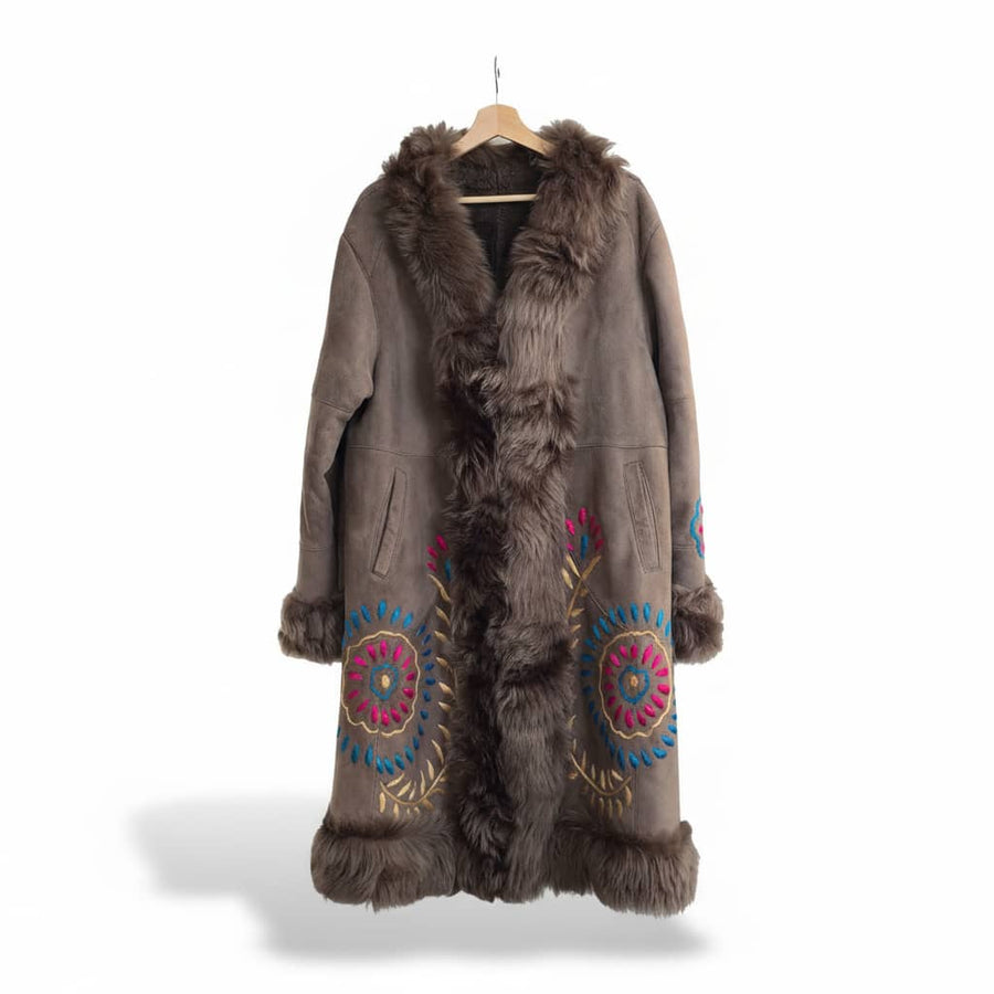 Brown suede coat with brown curly fur trim and colorful floral embroidery on the front panels on a white background