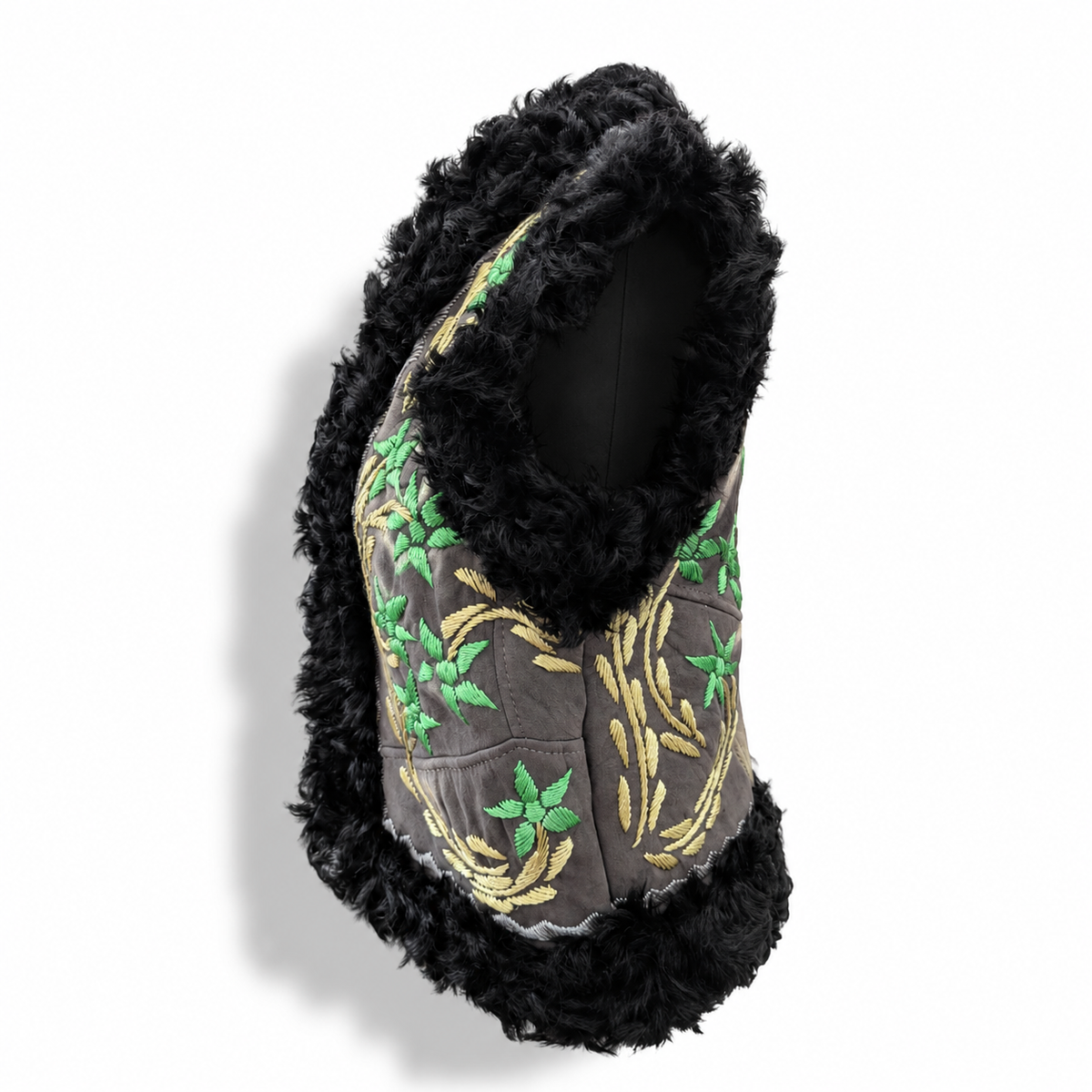 A black faux-fur trimmed vest with a gray front panel featuring green and gold embroidered floral and leaf patterns, displayed on a white background.