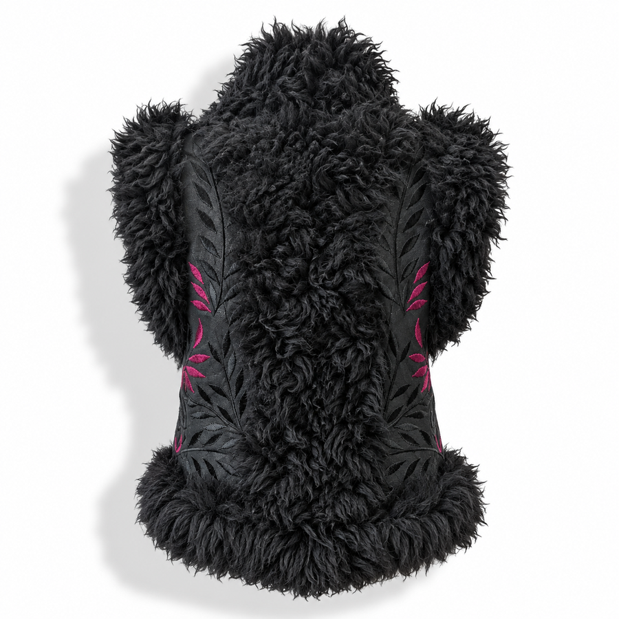 Back view of a black shaggy faux-fur vest with pink embroidered leaf patterns on the sides, displayed on a mannequin torso against a white background.