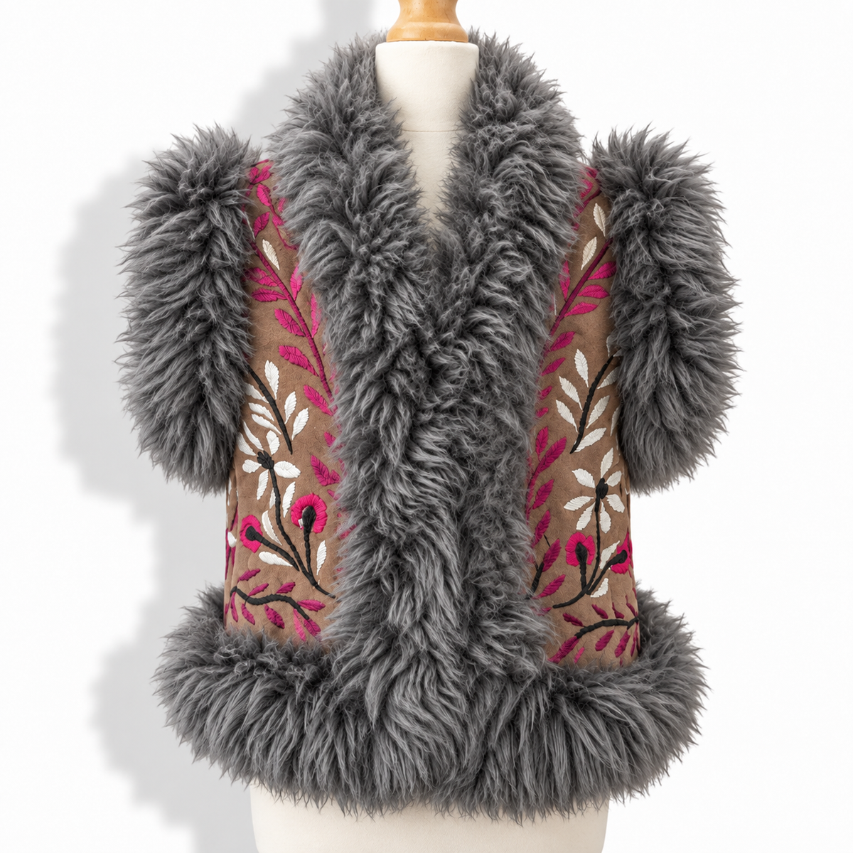 A gray faux fur vest with pink and white floral embroidery on the sides, displayed on a cream dress form mannequin against a white background.