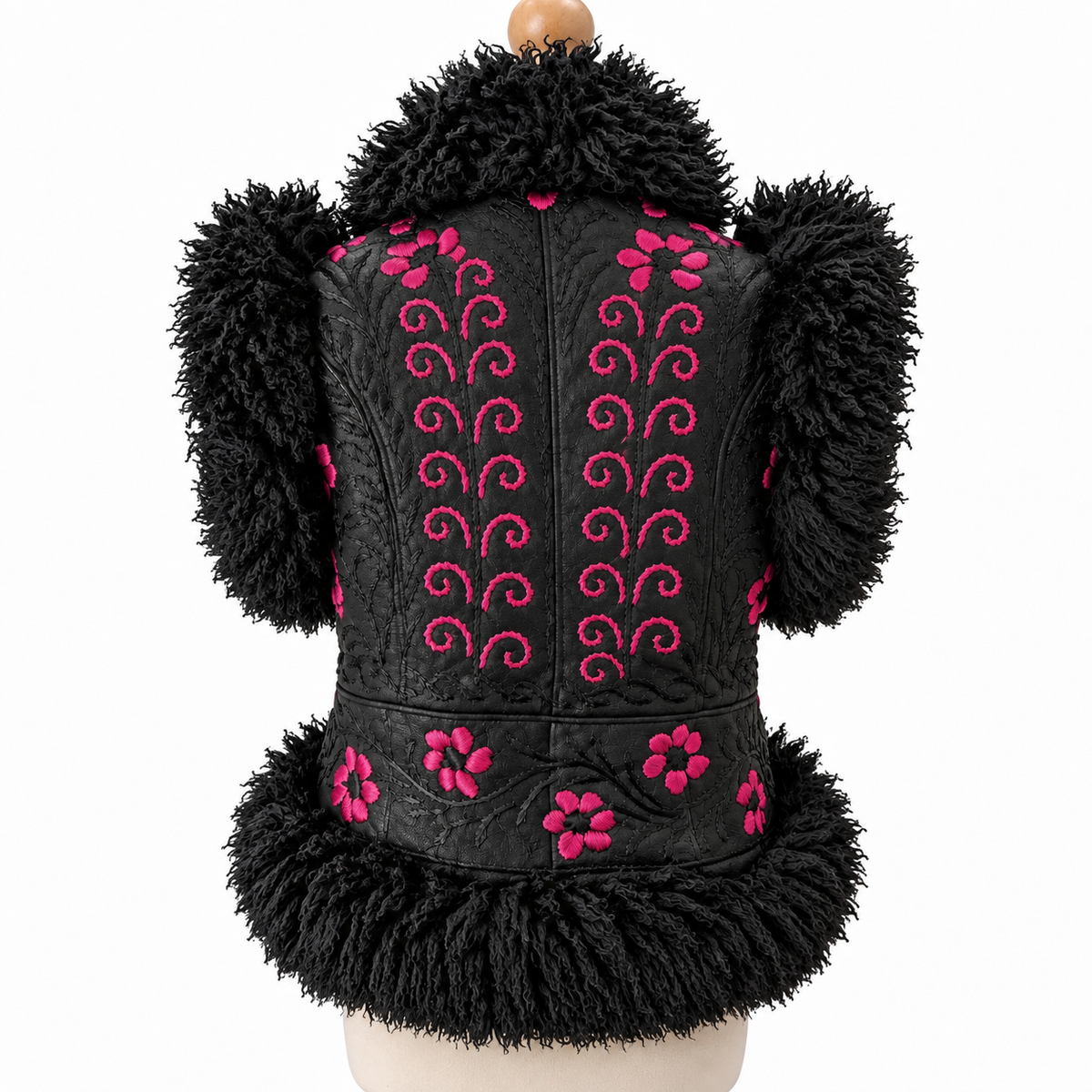 Black faux fur vest with pink embroidered swirls and floral patterns, displayed on a mannequin torso against a white background.