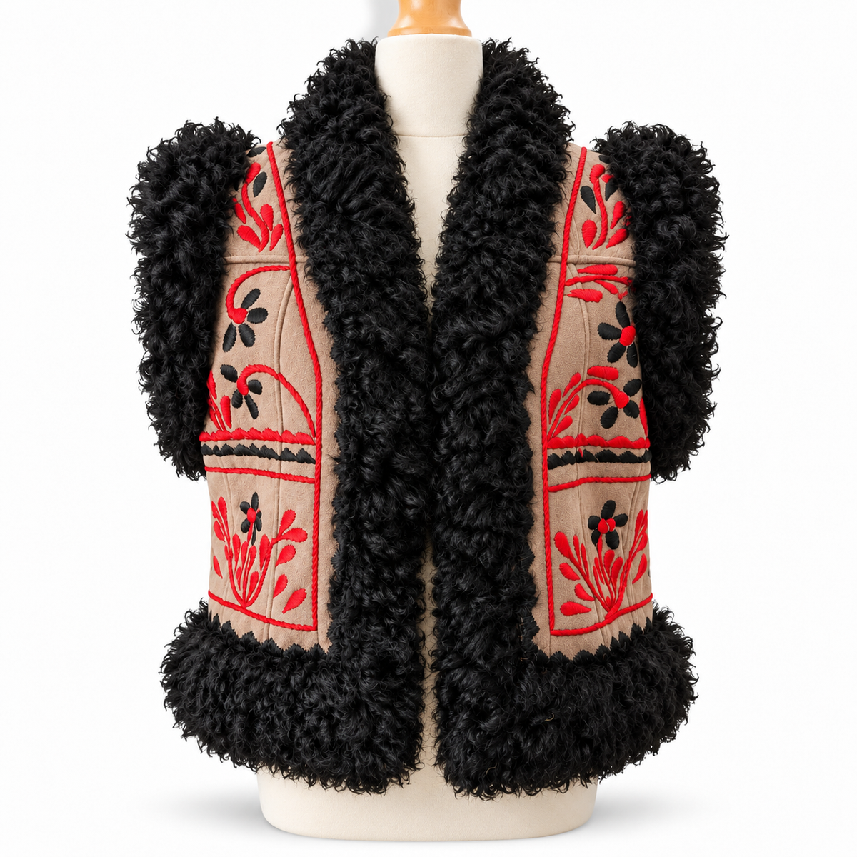 A black curly faux-fur vest displayed on a cream dress form against a white background. The vest features beige embroidered panels with red and black floral patterns.